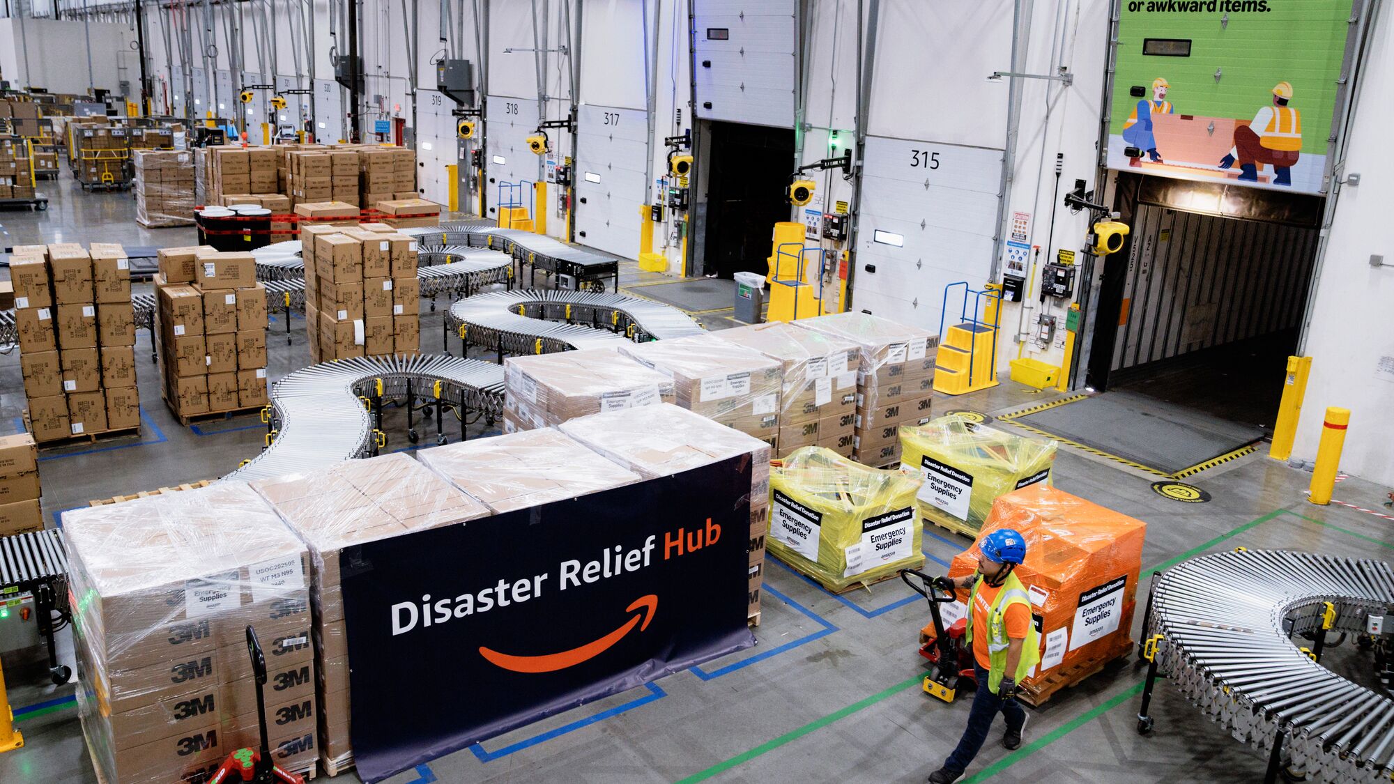 An Amazon employee moves donation item in a Amazon Disaster Relief Hub.