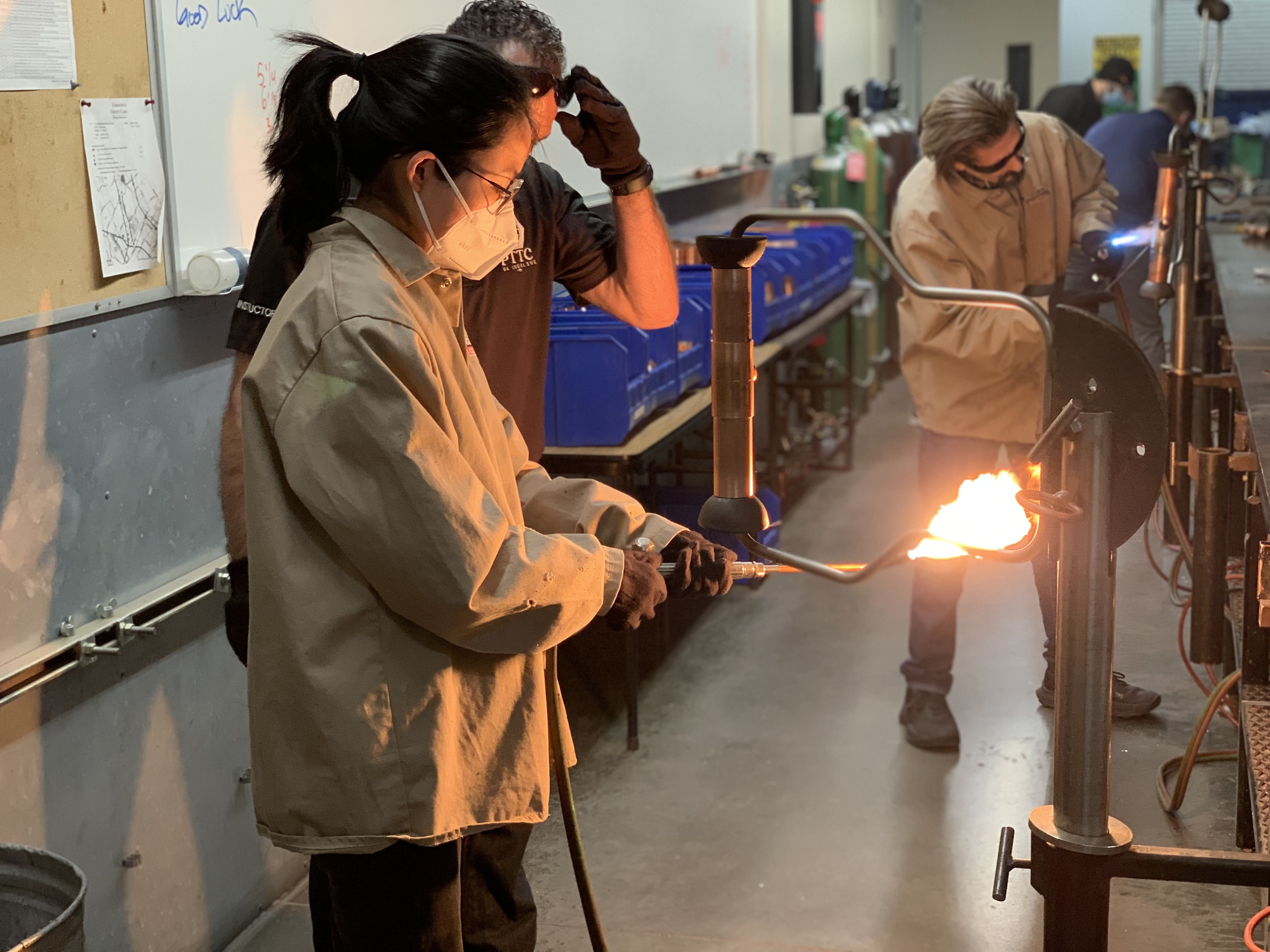 A student holds a blow torch in a lab. 