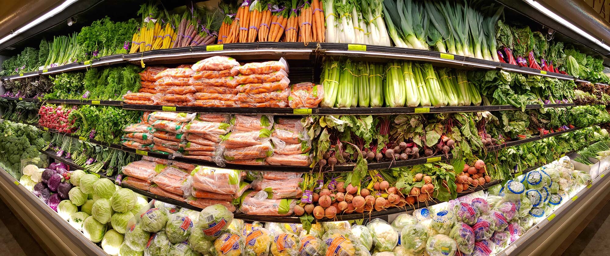 A panoramic image of a produce section in a Whole Foods Market store. 