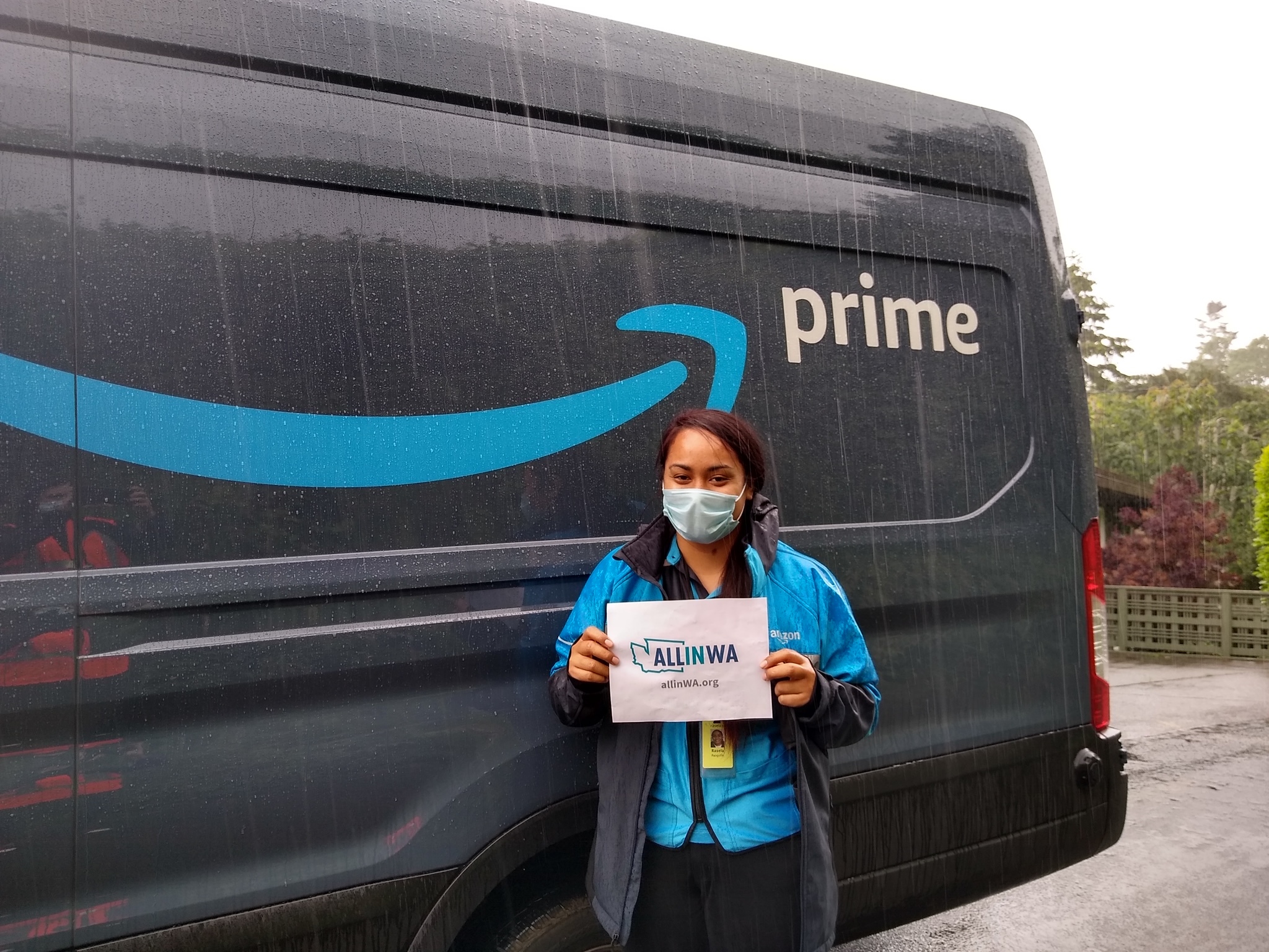 Amazon associate holds a sign that says "All in WA"