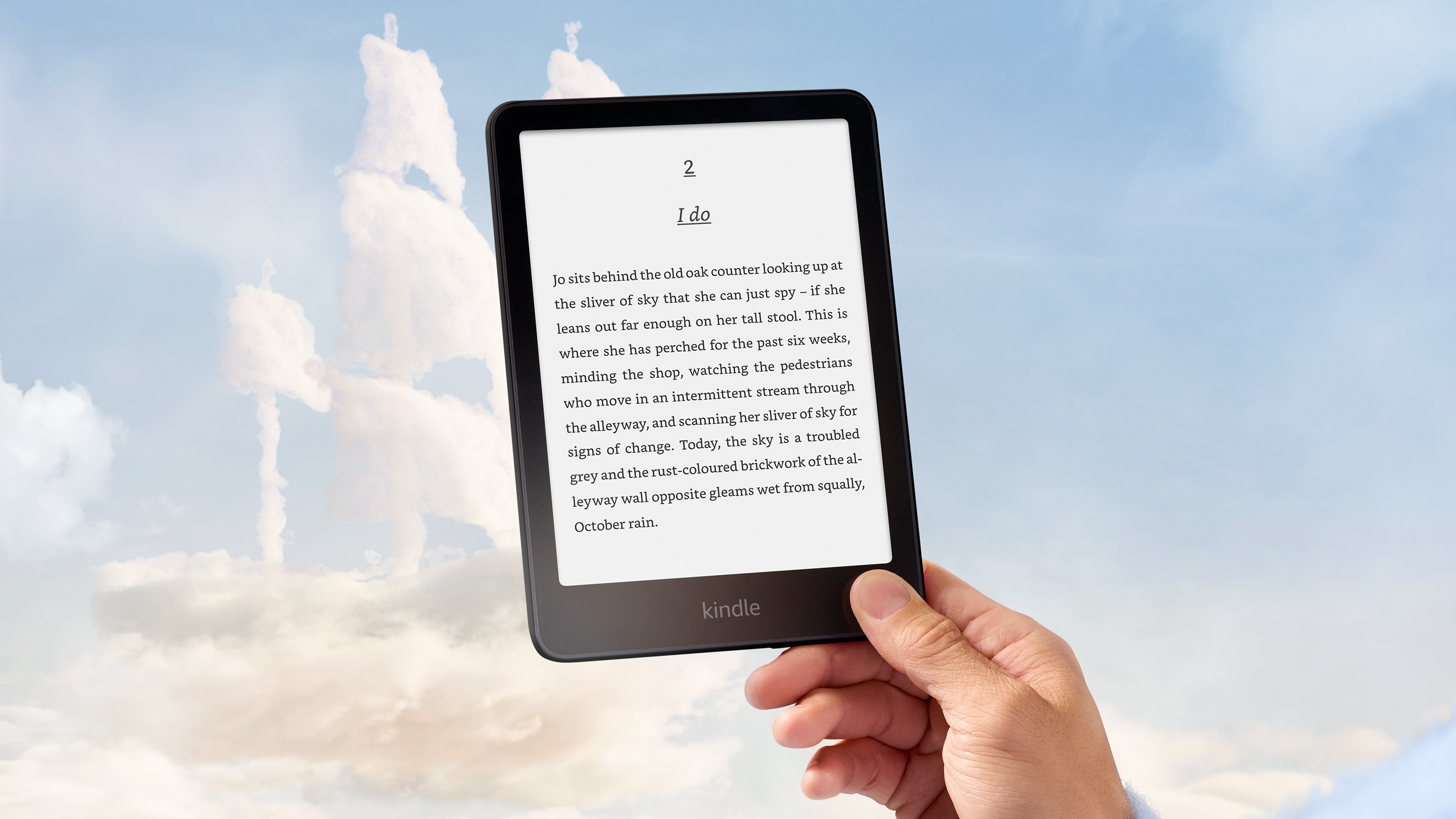 A hand holding up the new Kindle Paperwhite Signature Edition against the sky