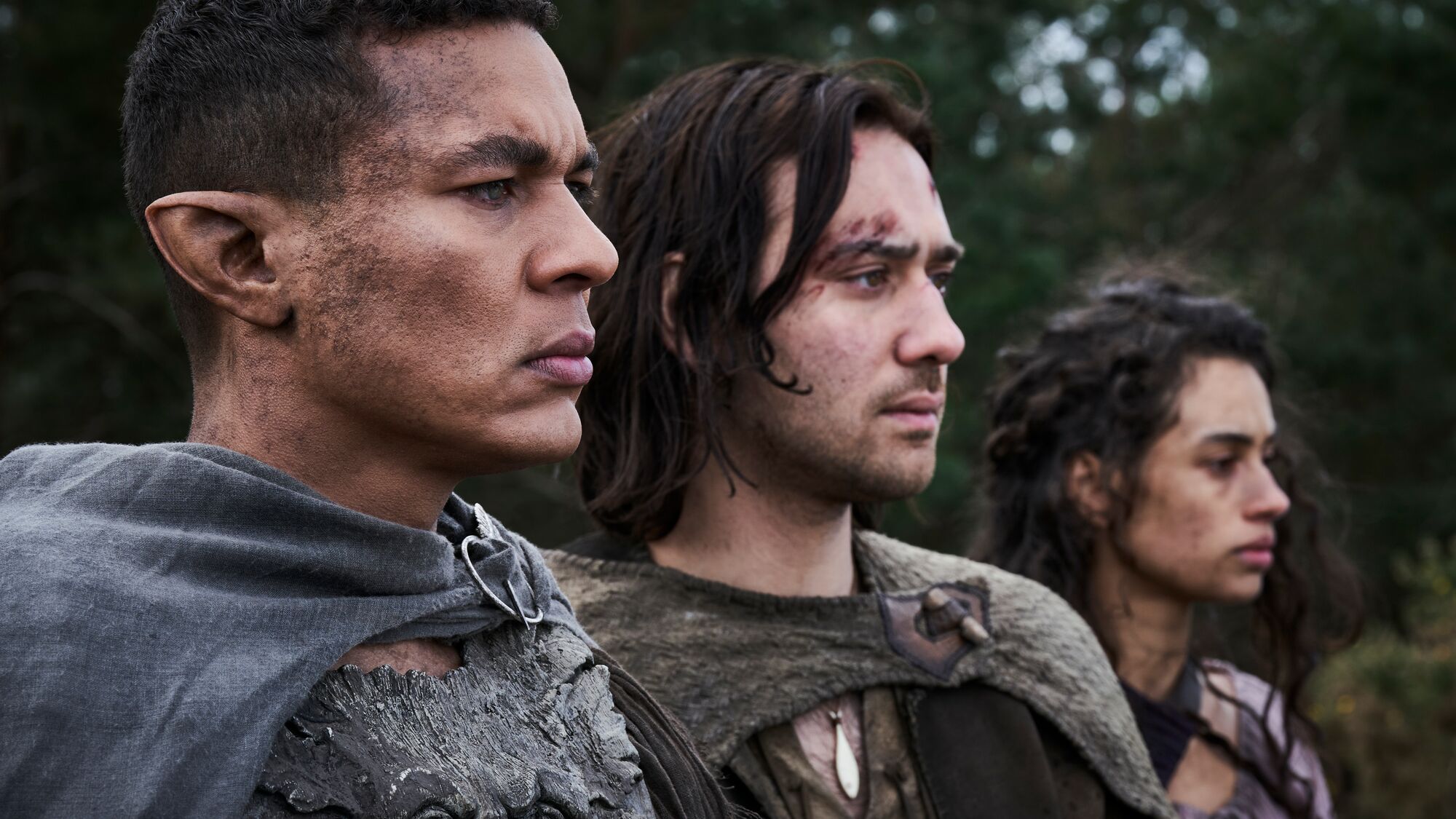 Three rugged characters in medieval-style attire looking intently ahead.