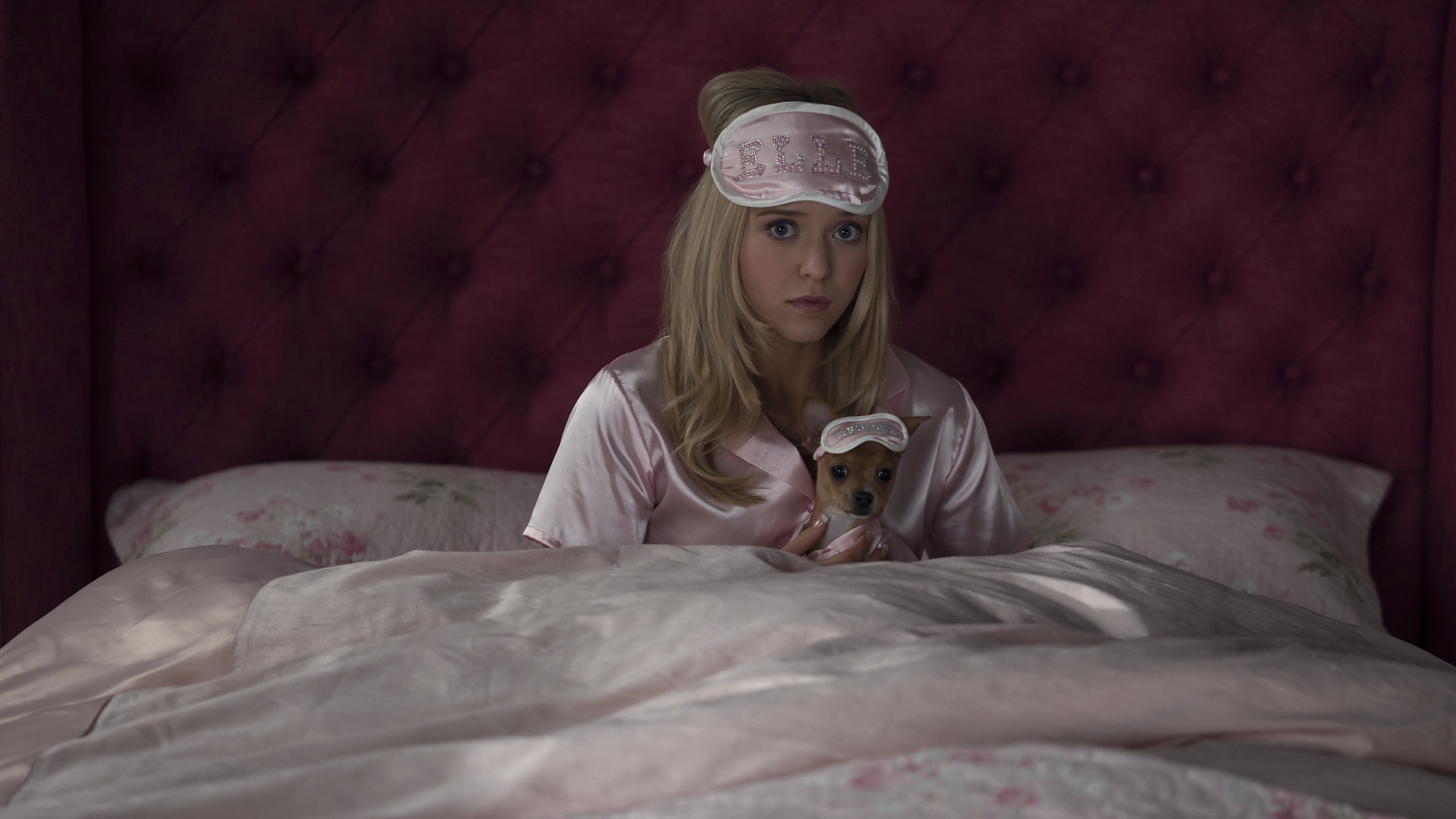 Lexi Minetree as Elle Woods in pink pajamas with matching sleep mask on her dog in the Amazon Prime series Elle