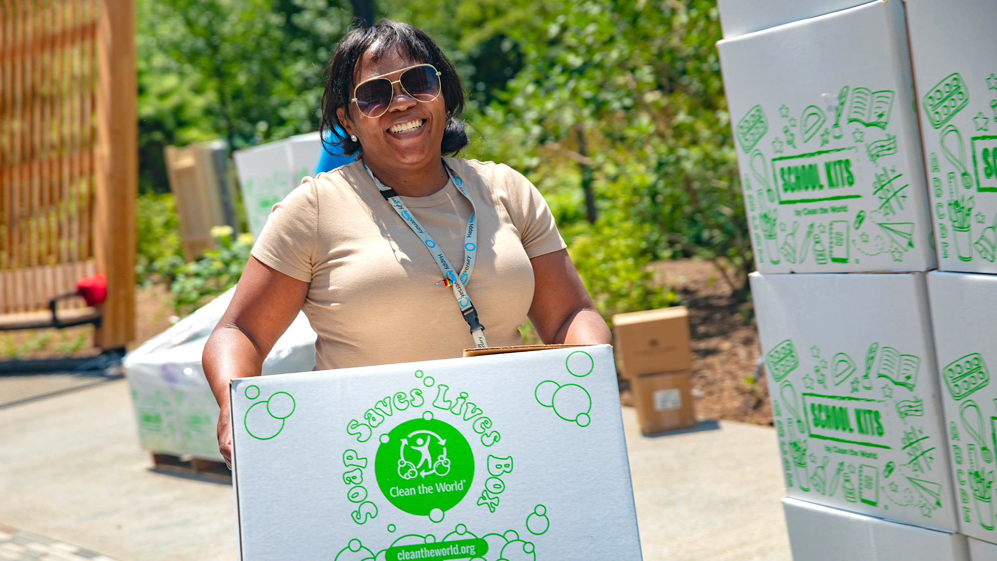 A volunteer part of Kitchen of Purpose holding a box of soap for donation.